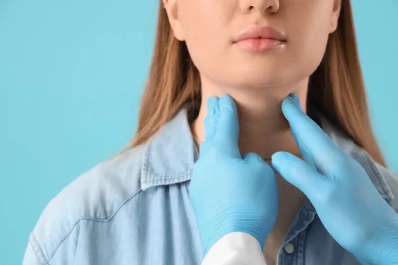 male,endocrinologist,examining,woman's,thyroid,gland,on,blue,background,,closeup